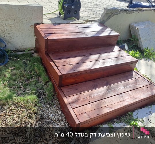 מדרגות עץ בגינה עם צמחייה מסביב